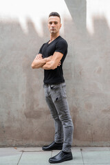 Obraz premium Full length shot of handsome young Italian man with undercut standing with arms crossed