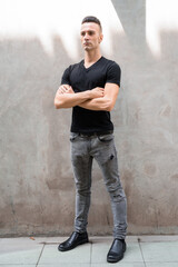 Full length shot of handsome young Italian man with undercut standing with arms crossed