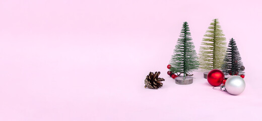 Christmas tree, red toys on pink background in minimal style. Decorative Christmas ornaments, new year and winter concept, banner, copy space