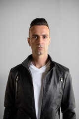 Obraz premium Handsome young Italian man with undercut wearing black leather jacket vertical shot
