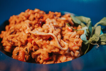 Closeup shot of pilaf with bacon and basil in a blue bowl