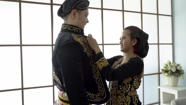 happy men and women wearing javanese traditional clothes. beskap and kebaya for java wedding