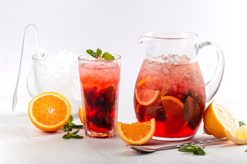 Side view on red berry lemonade in a jug and glass