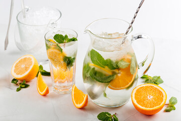 Orange and mint lemonade in a jug and glass