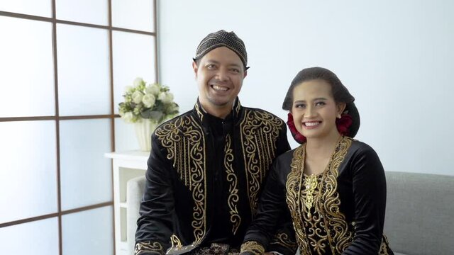 happy men and women wearing javanese traditional clothes. beskap and kebaya for java wedding