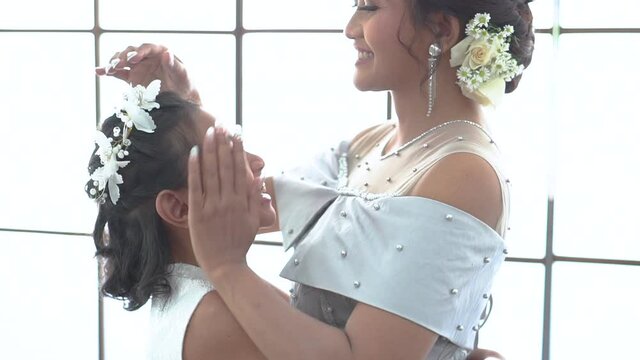 Portrait of a happy mother hugging her happy daughter. Familiy photo concept, standing by the window