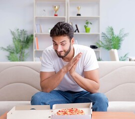 Man eating pizza having a takeaway at home relaxing resting