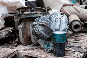 The drill bit, shot close-up with shallow depth of field. Industrial background. Tricone drilling...