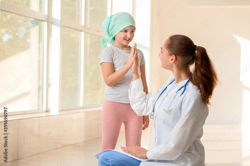 Wall mural Doctor and little girl in clinic. Childhood cancer awareness concept