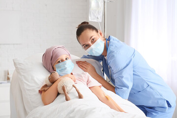 Nurse and little girl undergoing chemotherapy course in clinic