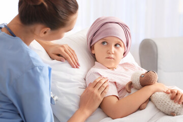 Nurse and little girl undergoing course of chemotherapy in clinic