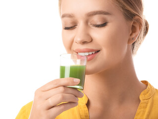 Young woman with wheatgrass juice on white background
