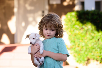 Cute kid and puppy playing outside. Pet care, kid puppy.
