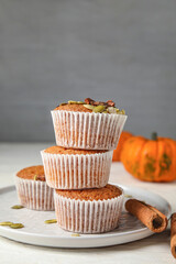 Plate with tasty pumpkin muffins on table