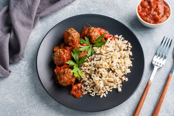 Beef meatballs and brown rice on a plate. Ready made portioned dish meat with garnish.