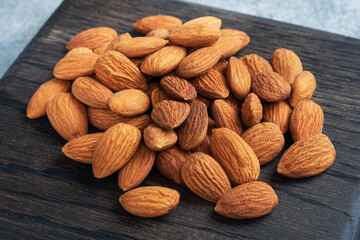 Peeled almonds on a wooden rustic background.