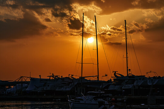 Contrasting silhouettes of yachts against the bright summer sunset sky