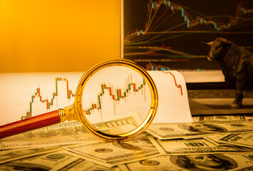 Magnifying glass on a diagram and paper money - accounting concept