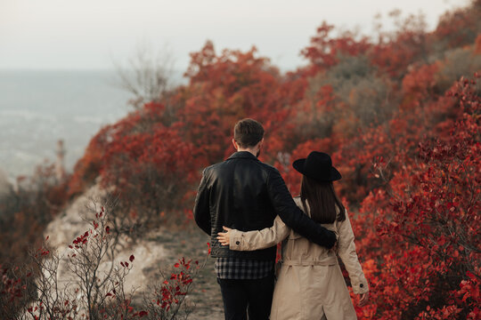 Stylish Couple Hugging And Walking In Autumn Park From Back.