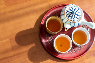 日の当たるテーブルに置かれた急須とほうじ茶の入った湯飲み