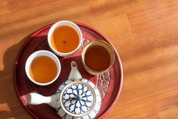 日の当たるテーブルに置かれた急須とほうじ茶の入った湯飲み