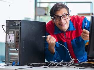 Computer repairman working on repairing computer in IT workshop