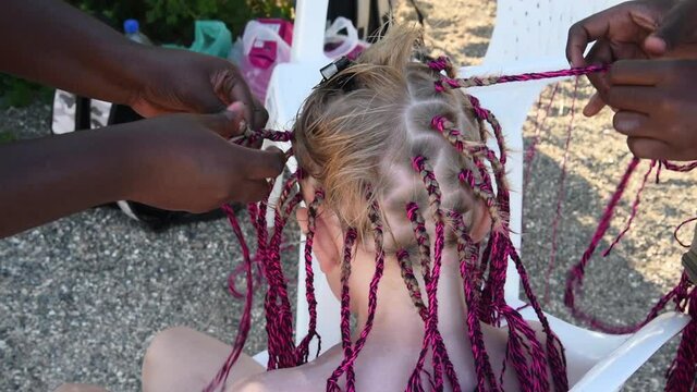 The process of weaving African braids. Girls braid African-American braids. Fashion and beauty