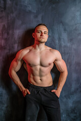 Handsome athletic man posing on black background.