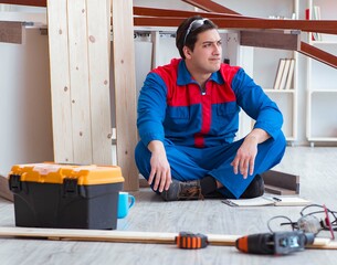 Young carpenter with notebook writing planning at construction r