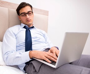 Businessman working in the bed at home