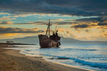 Fotobehang Roestig gebroken scheepswrak aan de kust © Voyagerix