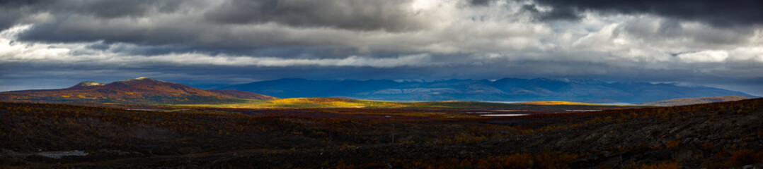 Stormy weather over the Khibiny mountains. First snow on the top of the cliffs. Panoramic view.