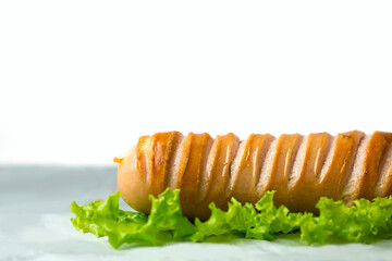 Toasted sausage with a green lettuce on the table