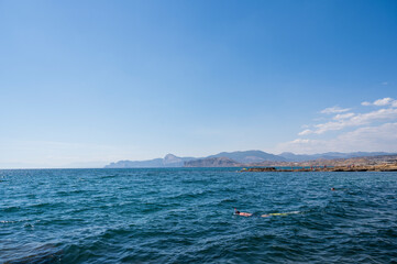 sea and sky, a man swims in the water