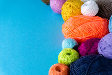 Various colored balls of yarn on a blue background. Threads for crocheting and knitting