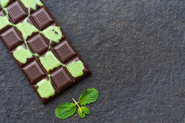 Mint chocolate on a dark stone background. Top view with copy space