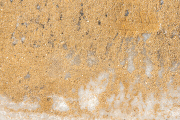 Texture of yellow sand on white ice. Sand is poured onto ice for safe movement, pedestrian care, traffic safety