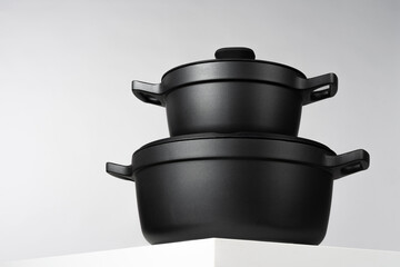 Black cooking pots on grey background front view