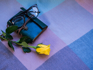 Retro notepad and yellow rose lie on the table. Notebook.