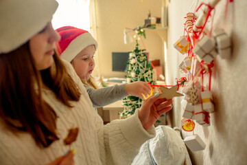 Kids opening Christmas presents.candy and gifts in advent calendar