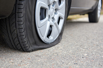 Fototapeta na wymiar Flat tire of a car, trouble on the road.