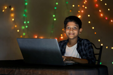 Cute indian little child using laptop at home