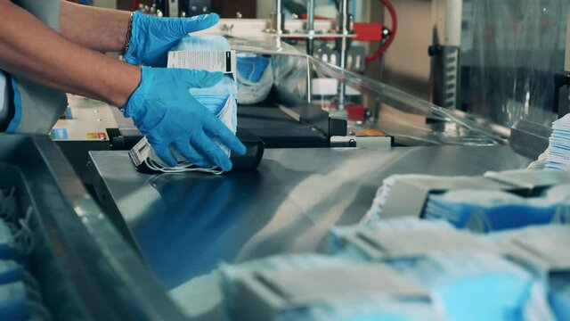 Covid-19 medical protection mask. Medical worker packing face masks using a special machine