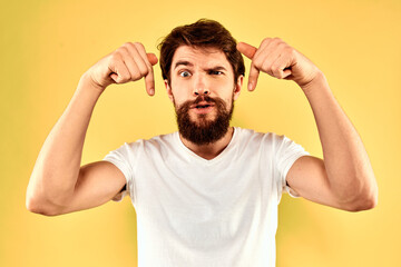 Fototapeta premium Bearded man emotions fun gesture with hands white t-shirt close-up yellow background