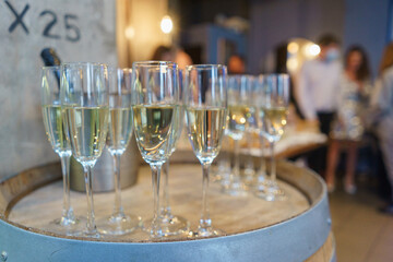 few transparent glasses with champagne on a rack in a bar or restaurant prepared for guests of festive events.