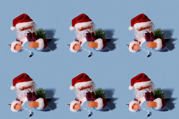 Pattern. Repetition of Santa's toy in a medical mask. Santa with gifts on a light blue background. Horizontal, free space on the left.Christmas and New Years concept.