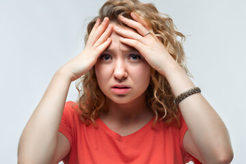 Fototapeta premium Photo of upset woman grabbing her head and rubbing temples because of headache. Human emotions facial expression concept