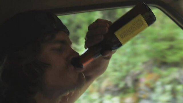 Alcohol fueled hillbilly driving recklessly on bumpy dirt road drinking beer
