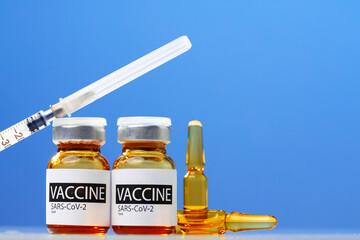 Sars-cov-2 vaccine vial and syringe on white table
