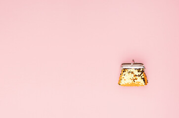 Elegant bright golden wallet with glitter on soft light pink color, top view, copy space.
